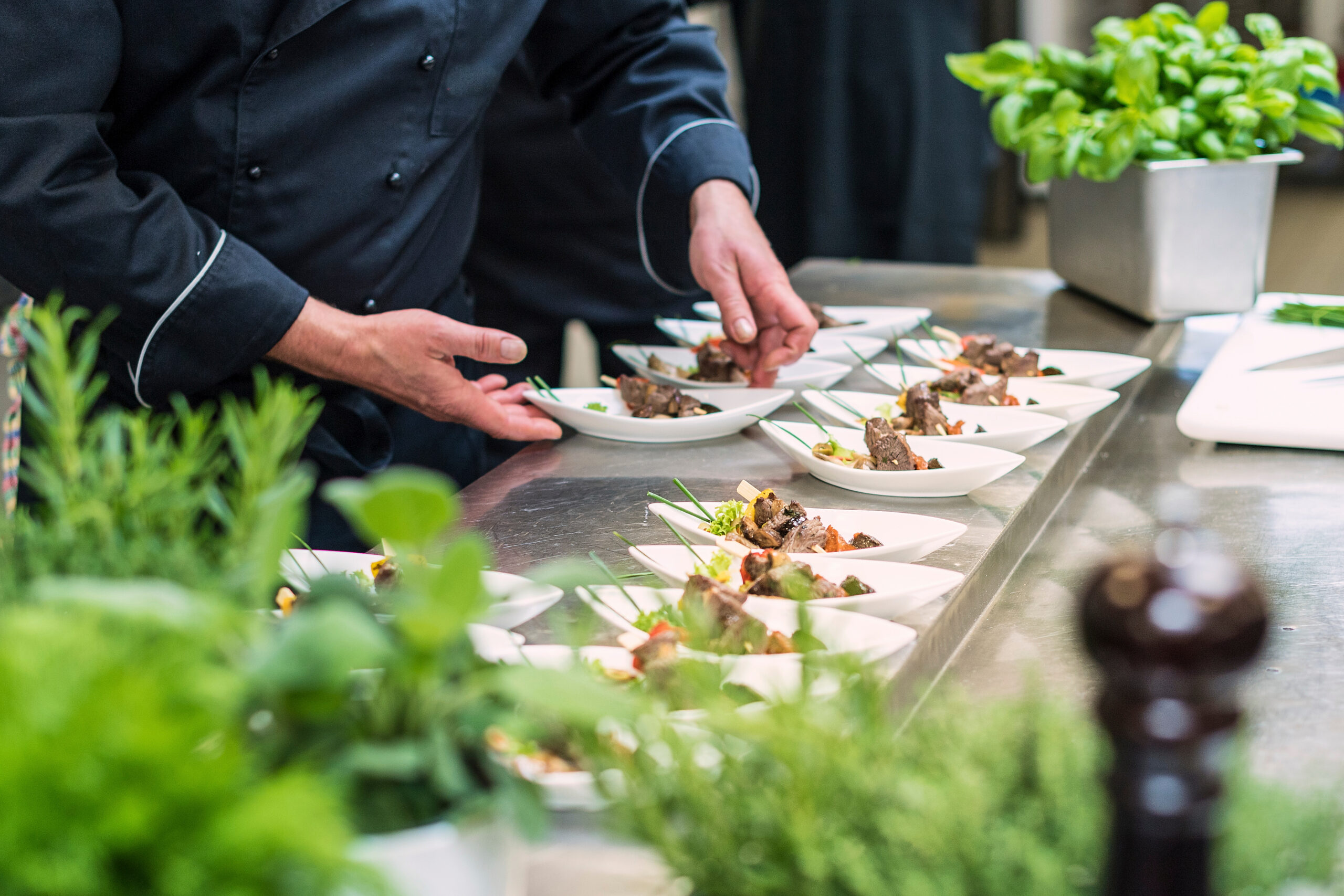 Catering Koch bereitet kleine Teller mit Spießen vor